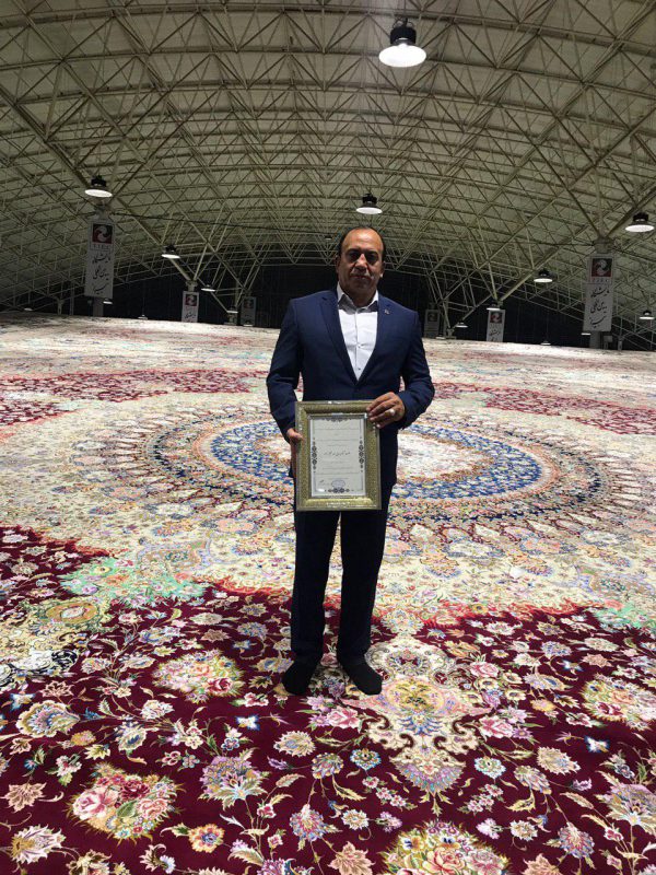 احد عظیم زاده در حال نمایش یک لوح تقدیر